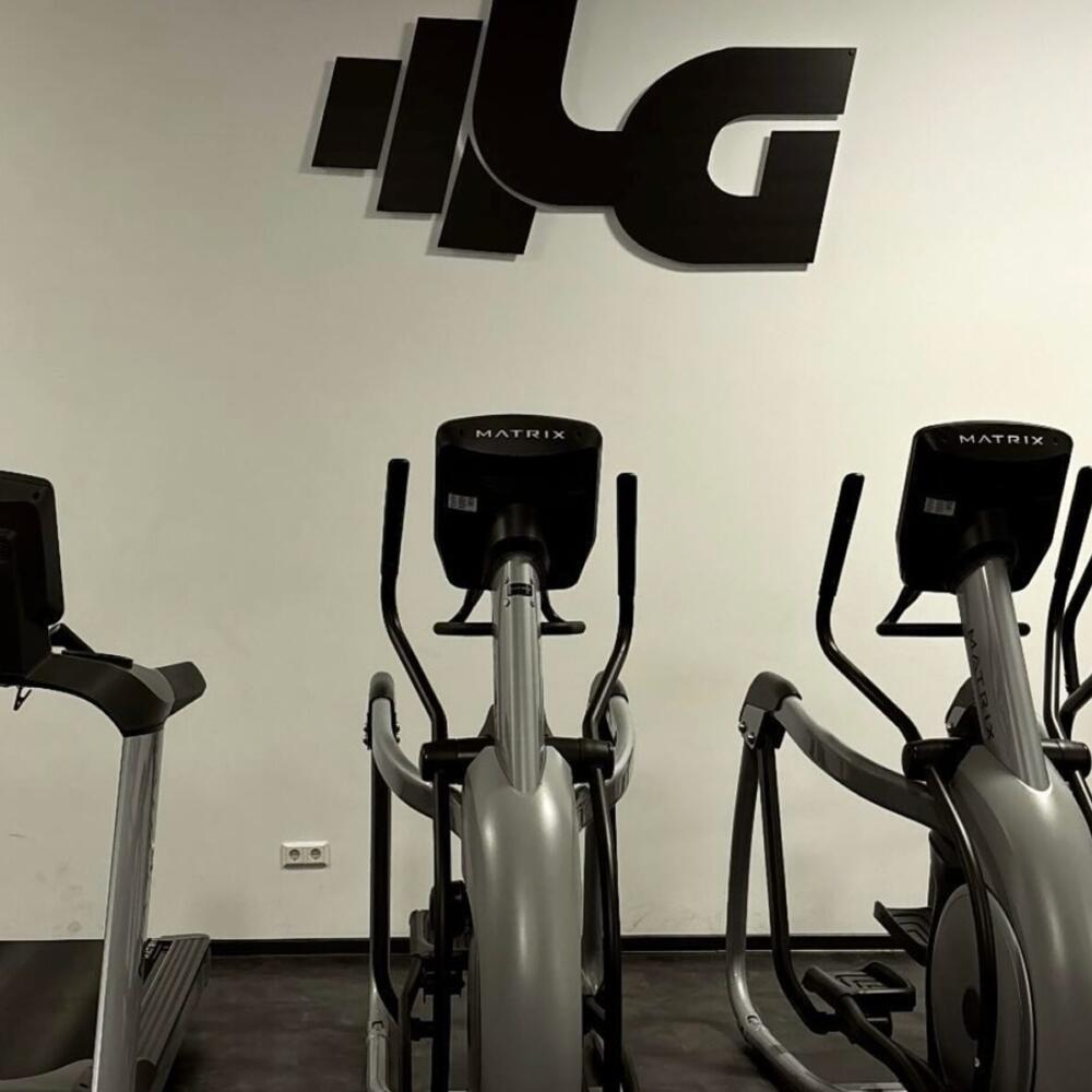 Crosstrainer im Fitnessstudio Eisenberg vor der Logo-Wand des Legends Gym.